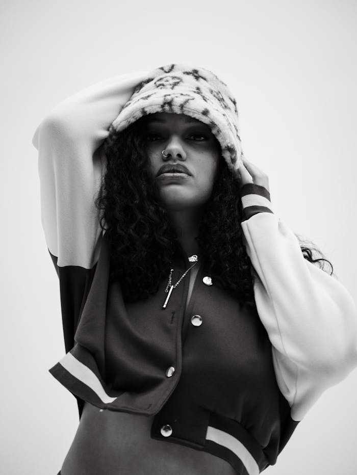 Stylish black and white portrait of a woman in fashionable attire with a confident pose.