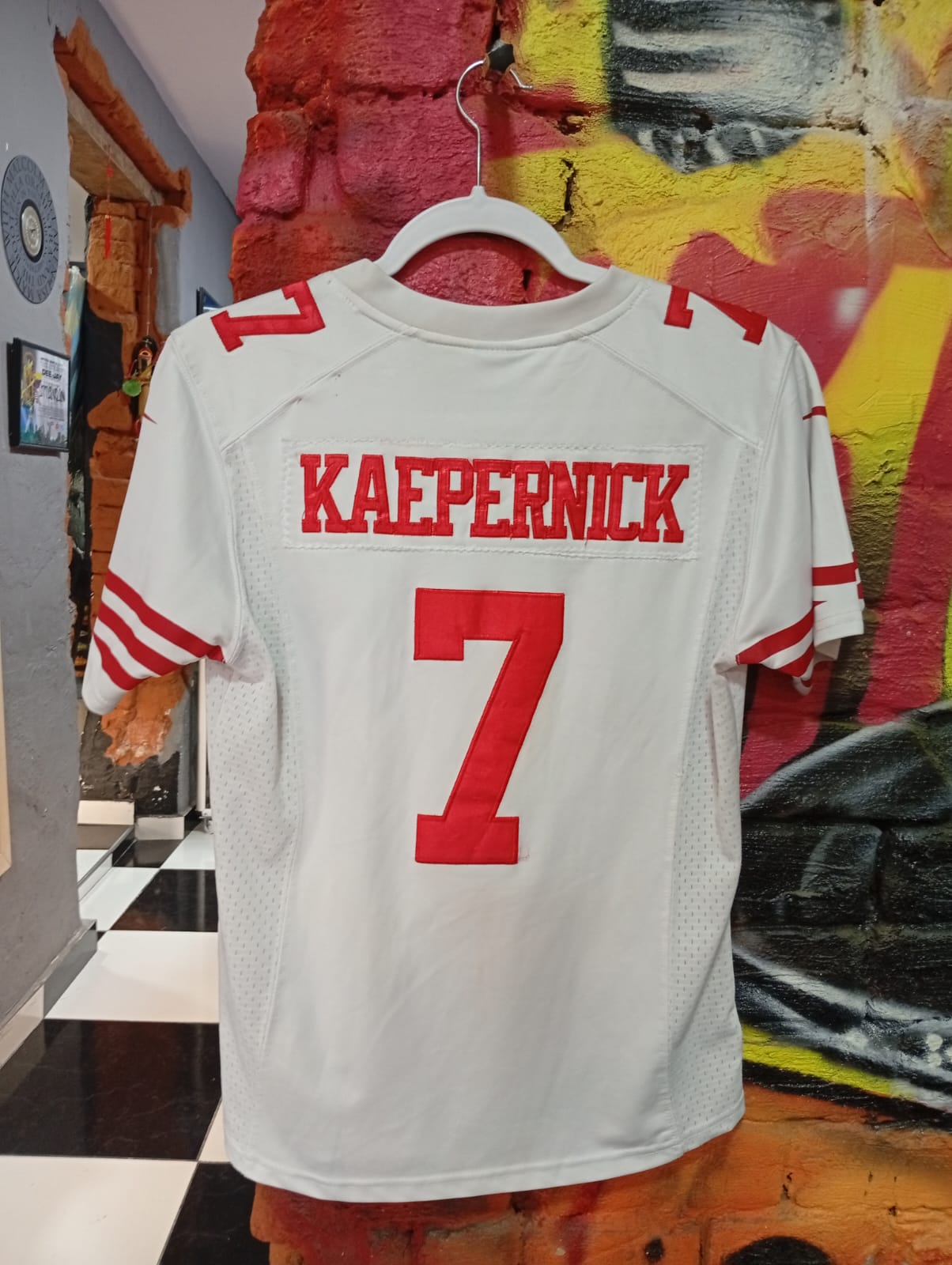 camiseta blanca marca Nike del jugador Colin Kaepernick San Francisco 49ers NFL. rras camiseta blanca marca Nike del jugador Colin Kaepernick San Francisco 49ers NFL tras.